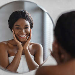 Mirror reflection of young black woman
